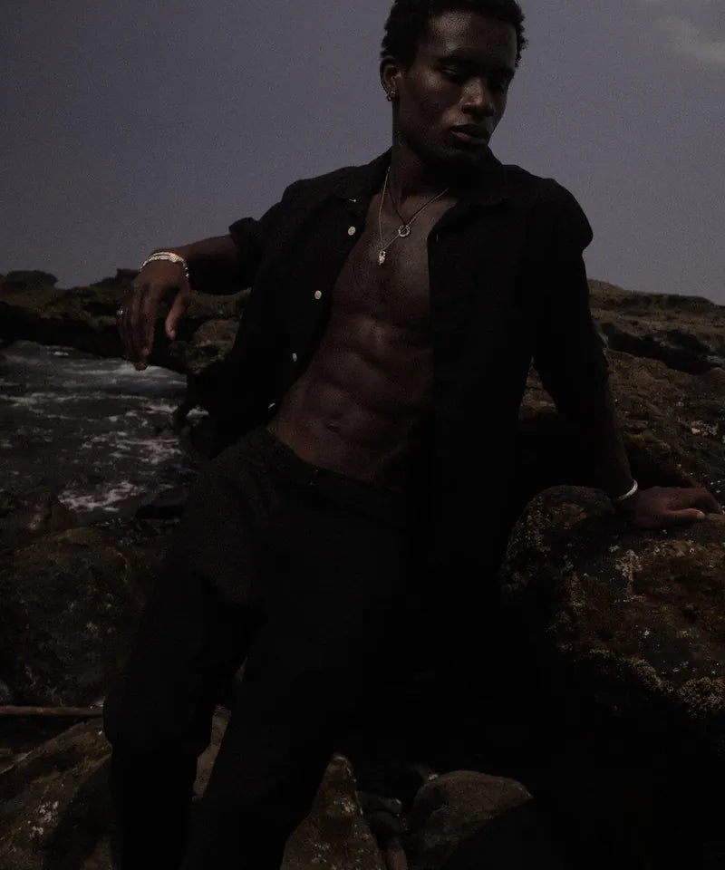 Model auf dunklem Felsen am Meer, Melted Kollektion